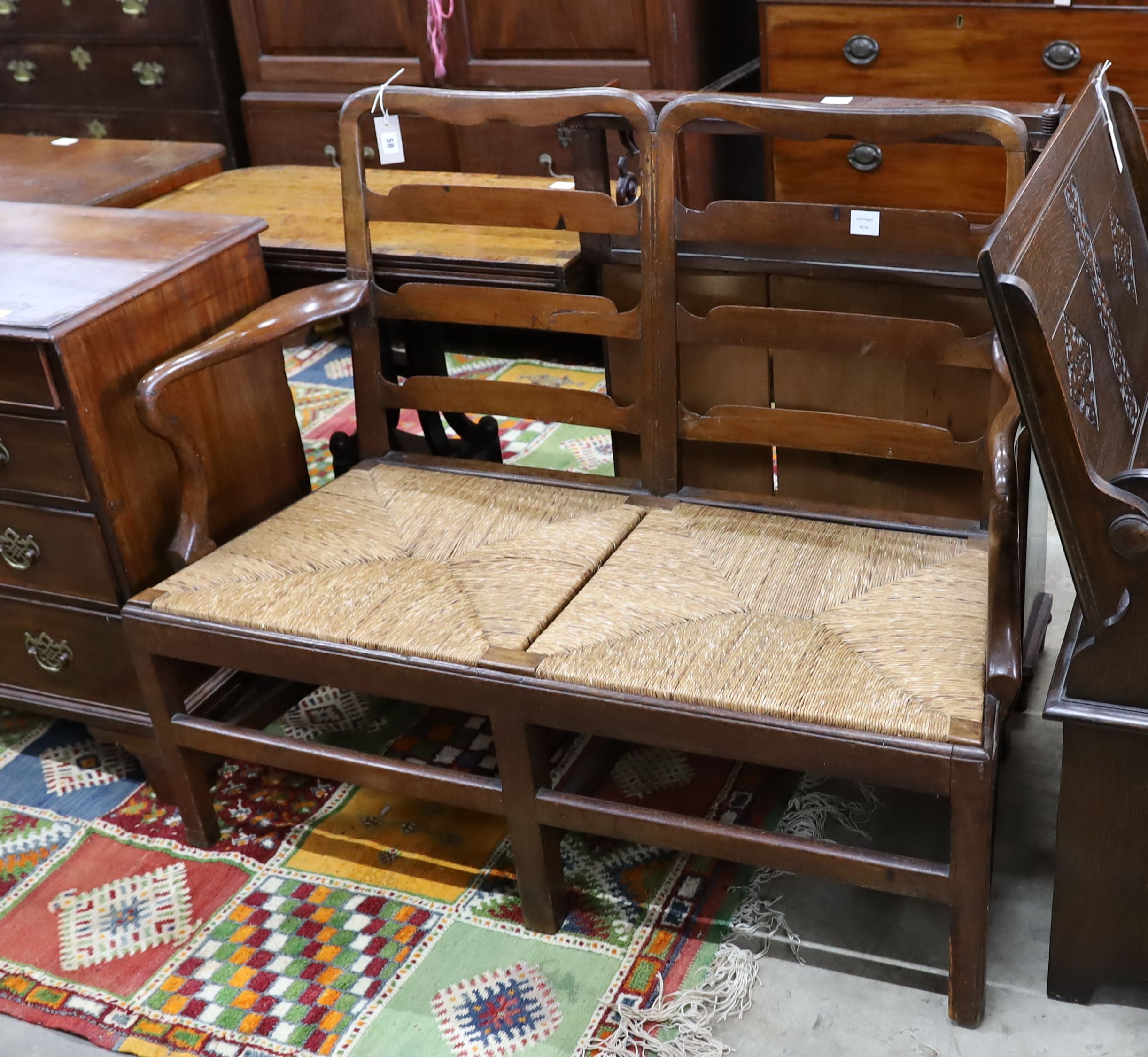 A George III provincial mahogany rush seat chair back settee, length 118cm, depth 53cm, height 100cm